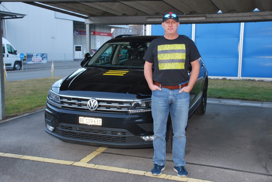 roland briggen, fahrlehrer bei drive cool, vor dem fahrschulauto